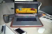 turned on MacBook Pro beside gray mug
